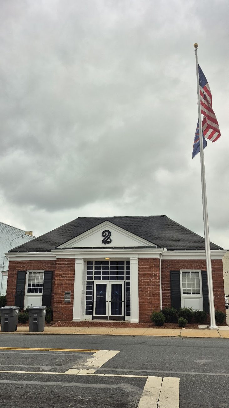 TruForge Homes storefront with flag, corner of Church St S and Cabarrus Ave E, Concord NC